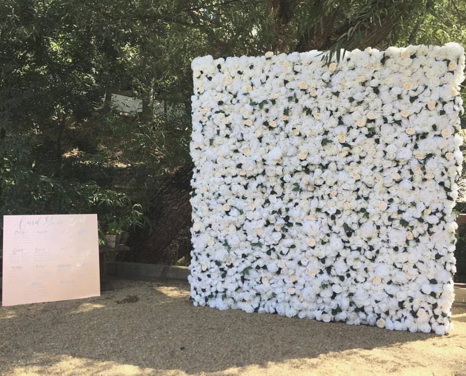 White flower wall with wedding seating chart
