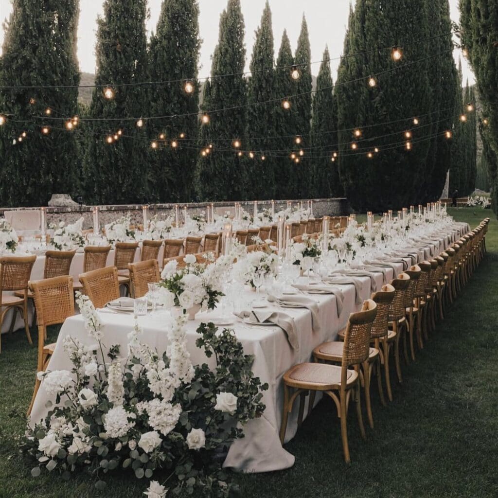 Elegant outdoor wedding reception with long flowered tables.