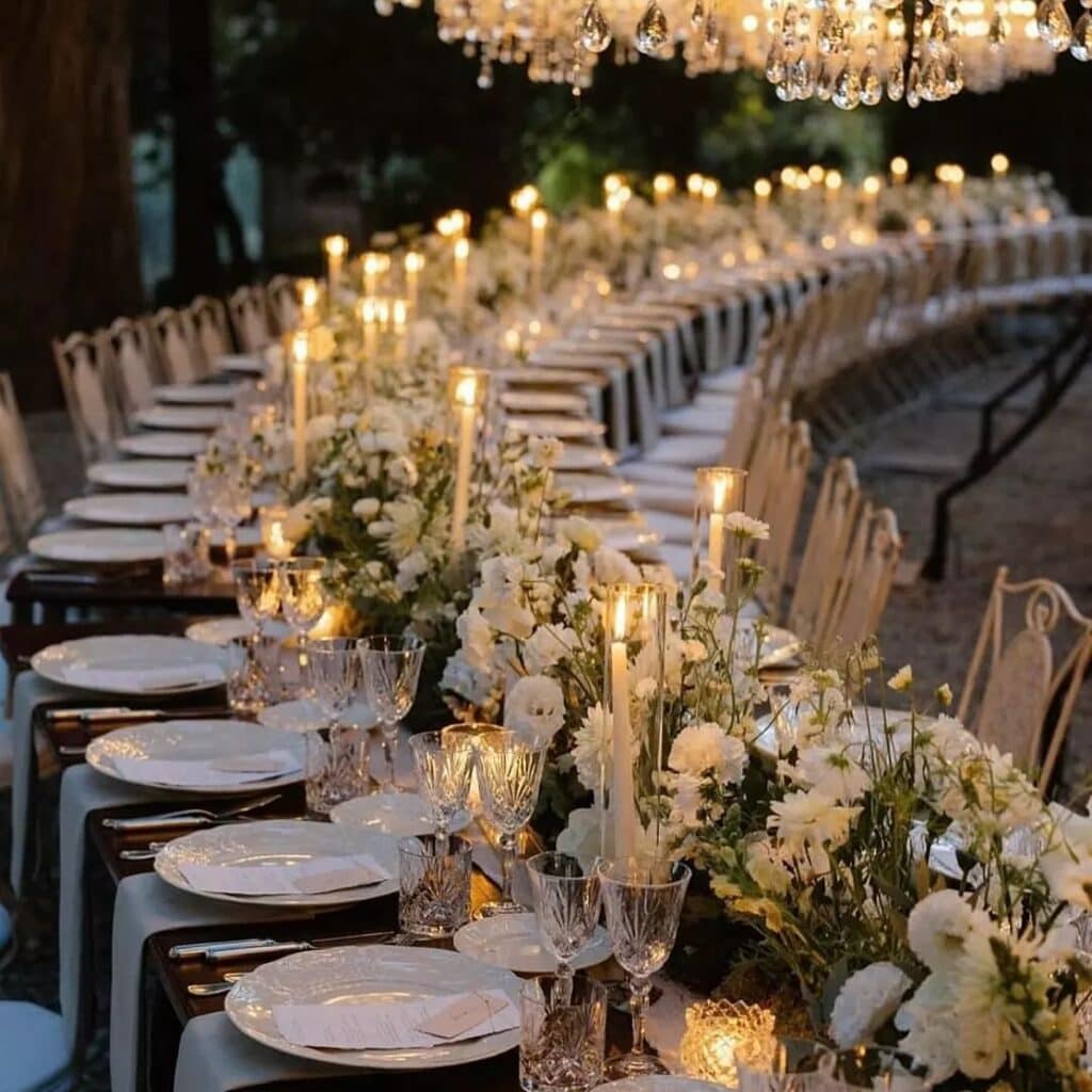 Elegant outdoor dinner setup with flowers and candles.