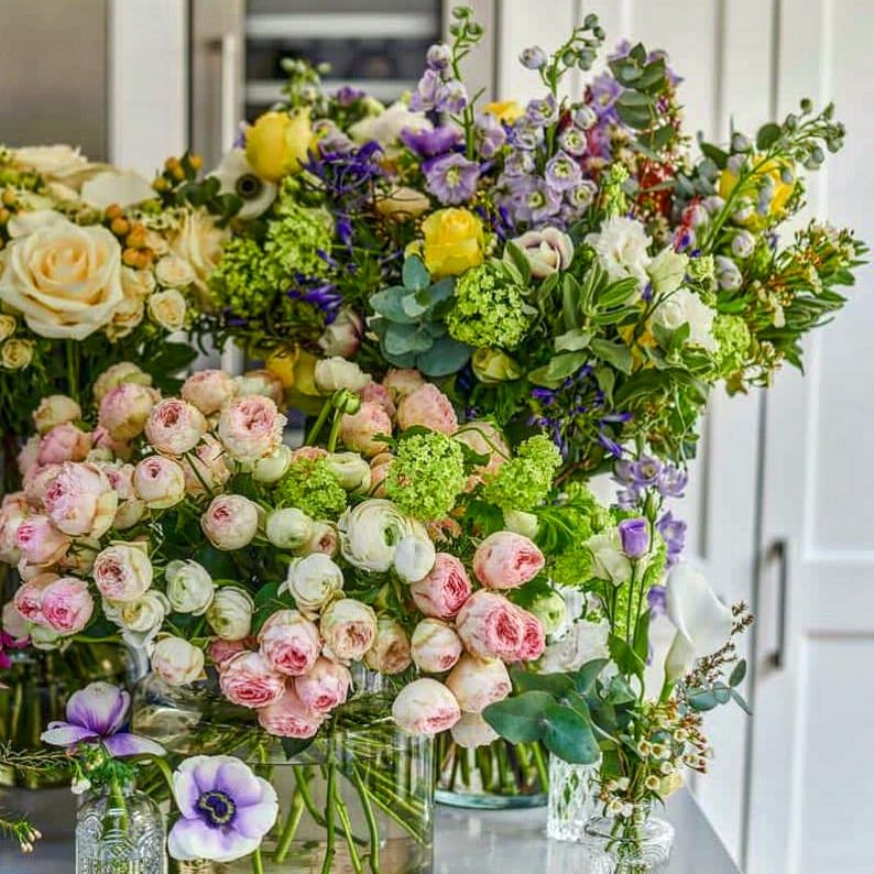 Colorful bouquet of various flowers in vases.
