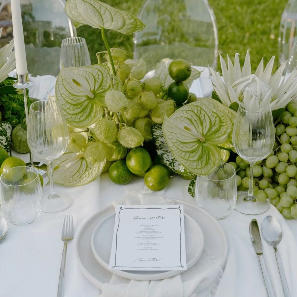 Elegant table setting with green floral centerpiece arrangement by Flower Gypsies Los Angeles