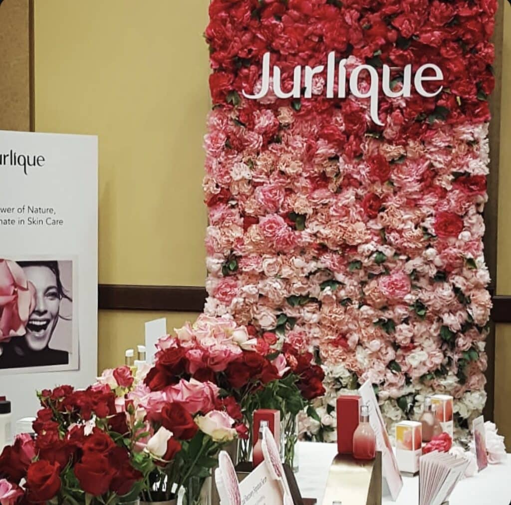 Jurlique floral display with skincare products.