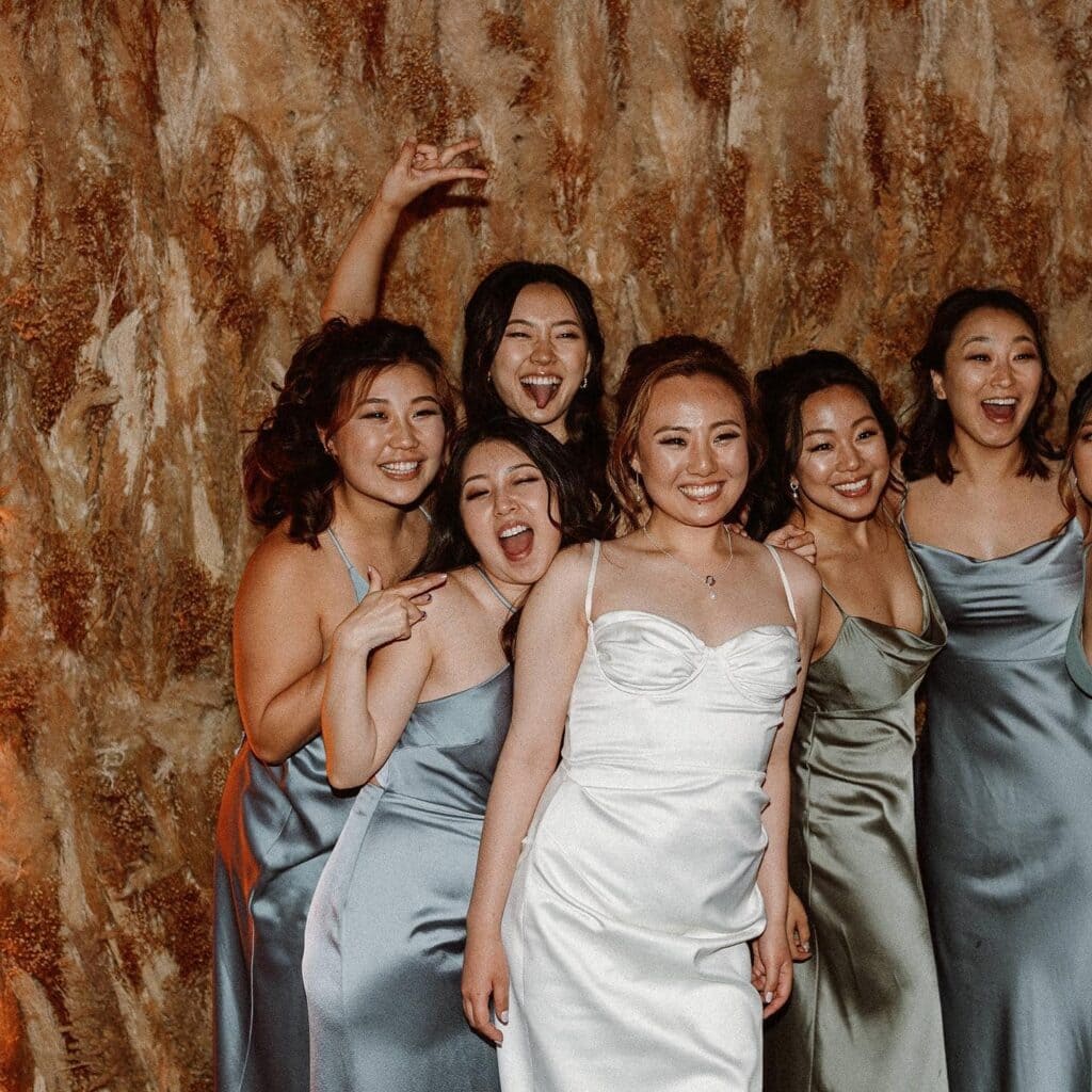 Group of women in formal dresses, smiling joyfully.