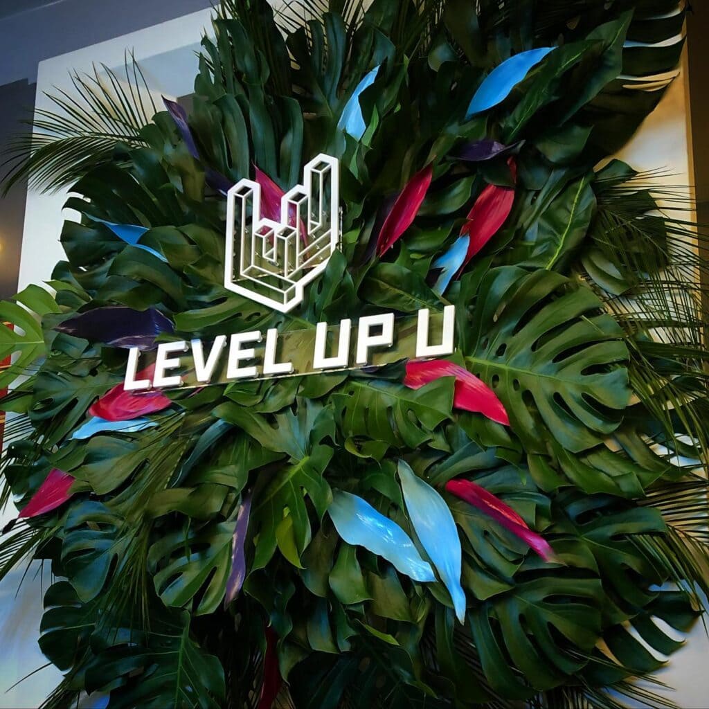 Level Up U logo with tropical leaves background